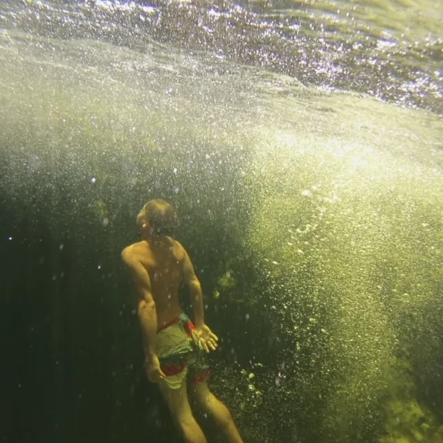 Underwater view of a surfer diving beneath a wave